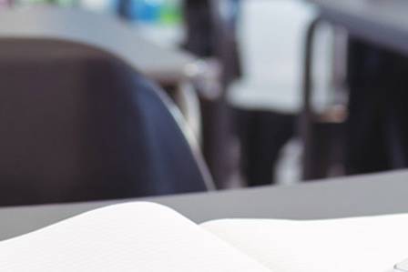jar full of pencils in an empty classroom