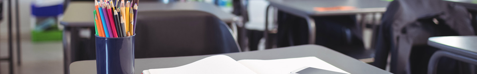 jar full of pencils in an empty classroom