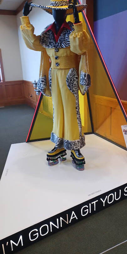Yellow pimp costume with glass platform shoes and wide-brimmed hat