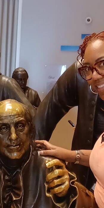 Ta-Tanisha Pierre with a statue of Ben Franklin.