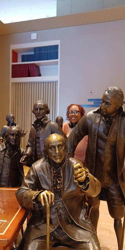 Ta-Tanisha Pierre with a statue of Ben Franklin.