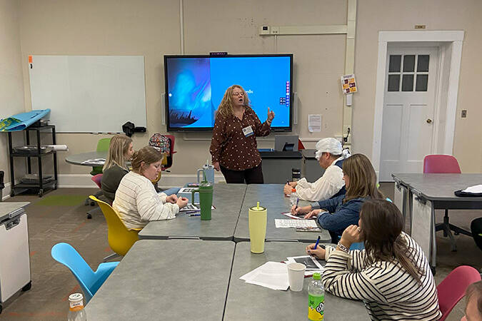 Jennifer Gribben presenting about storyboards at the end of a conference table