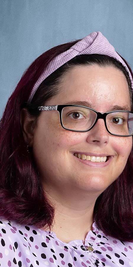Dark-haired woman in a polka-dot blouse