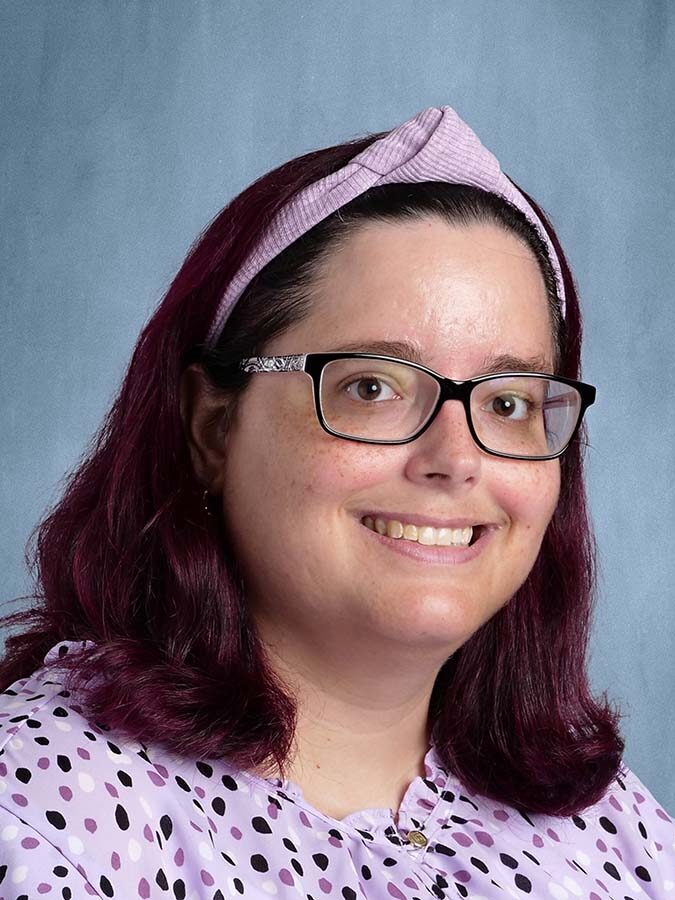 Dark-haired woman in a polka-dot blouse