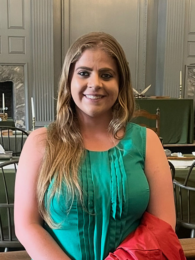 Smiling blonde woman in a green blouse.