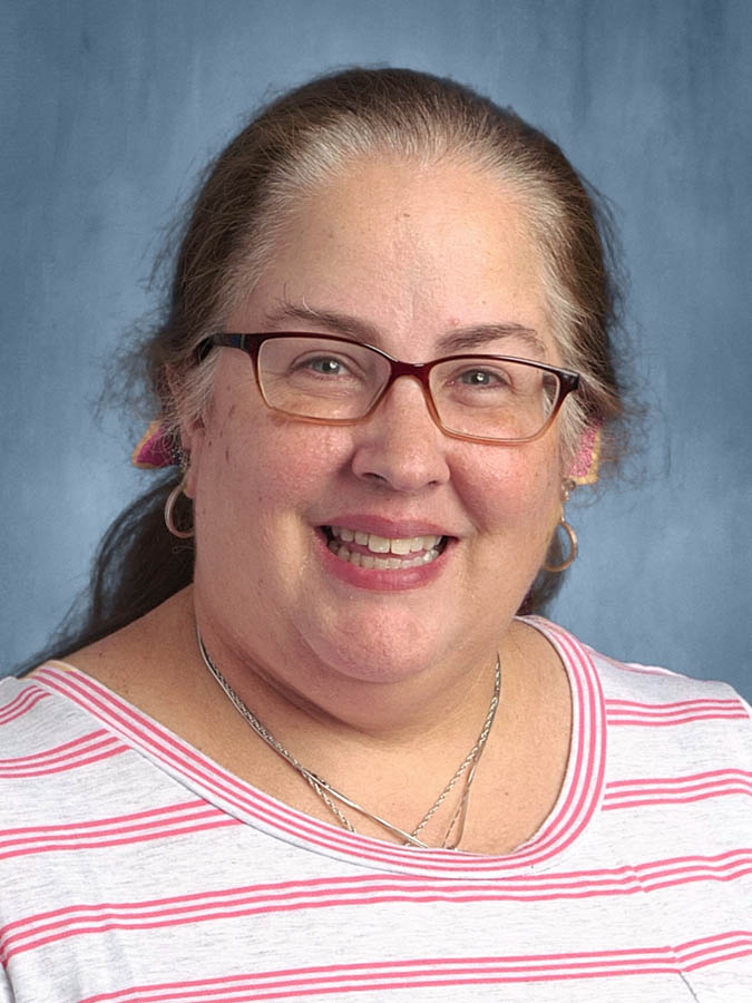 Smiling white woman in a pink-and-white striped blouse.