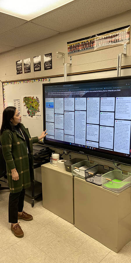 Teacher standing in front of a screen.