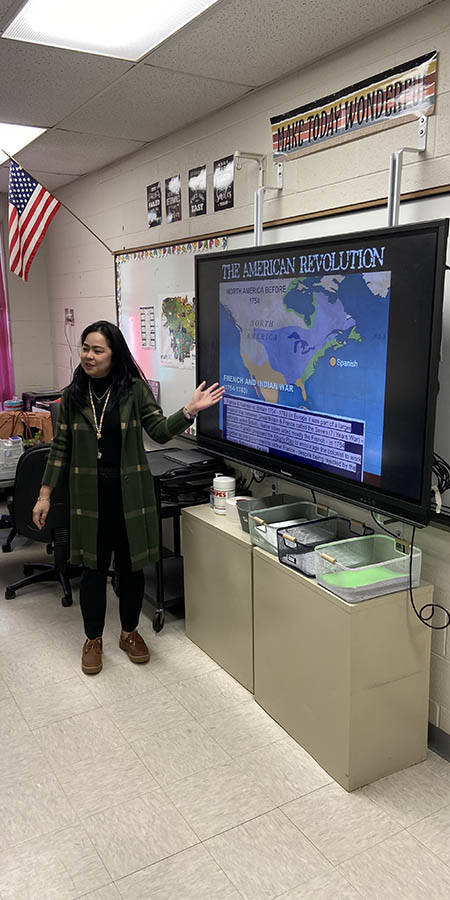 Teacher standing in front of a screen.