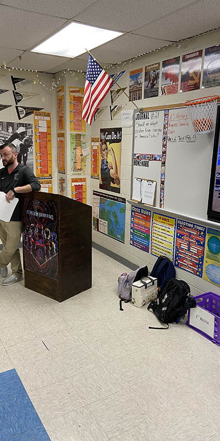 Teacher leaning on a podium.