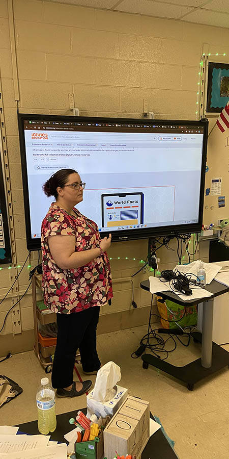 Teacher standing in front of a display a screen