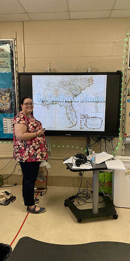 Teacher standing in front of a display screen