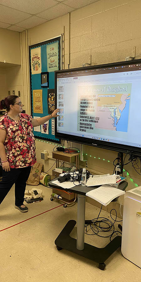 Teacher standing in front of a display screen