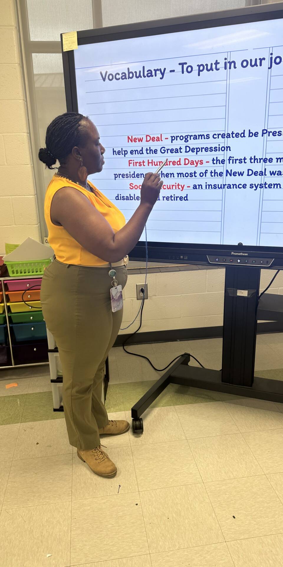 Teacher standing in front of a digital screen with information about the New Deal.