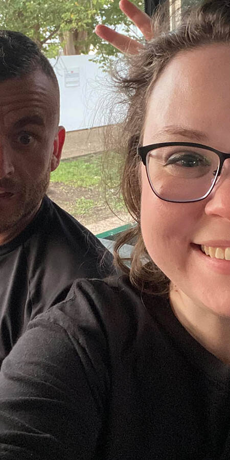 A man on the left makes a face at the camera while a woman at right smiles.