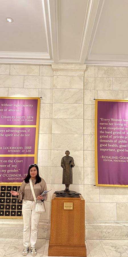 Woman standing by magenta banners.