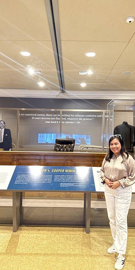 Woman standing next to a museum exhibit.