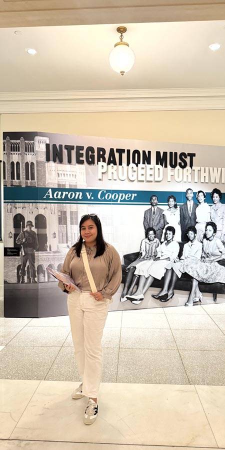 Woman standing next to a museum exhibit.