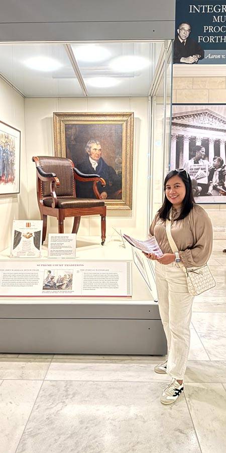 Woman standing next to a museum exhibit.