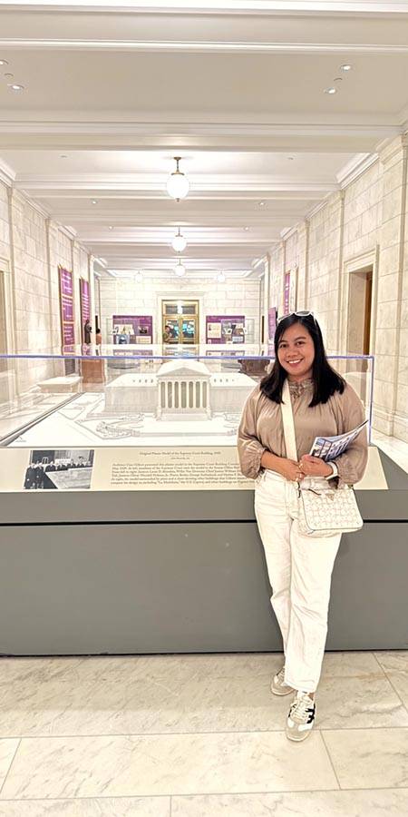 Woman standing next to a museum exhibit.