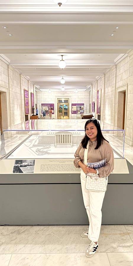 Woman standing next to a museum exhibit.