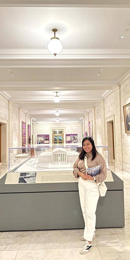Woman standing next to a museum exhibit.
