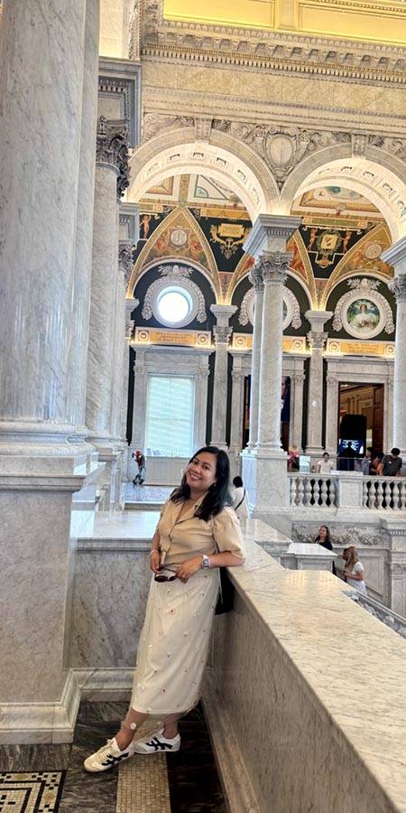 Smiling woman leaning against marble balcony