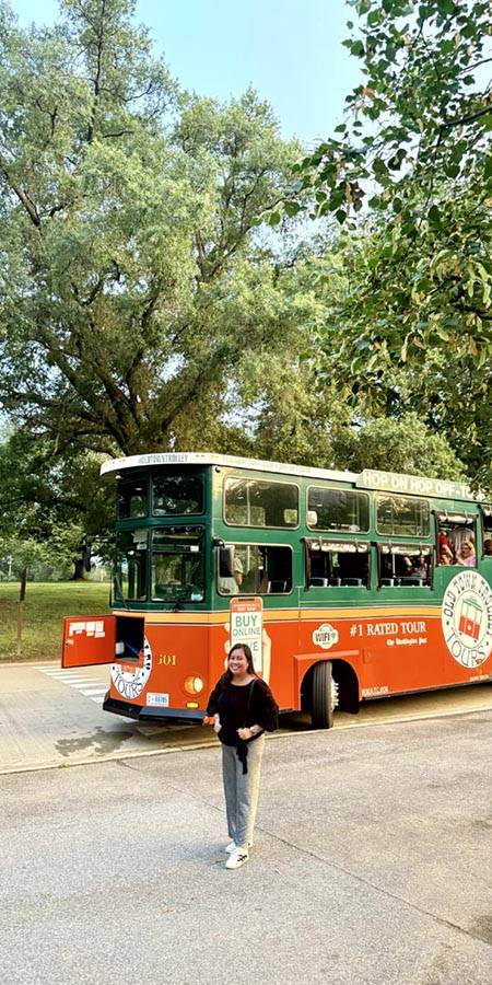 Woman standing in front of tour bus.